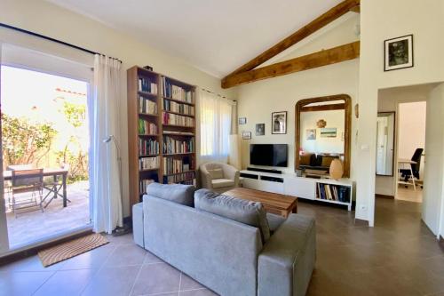 a living room with a couch and a television at La Poétique - Air-conditioned house with 3 bedrooms! in Montpellier