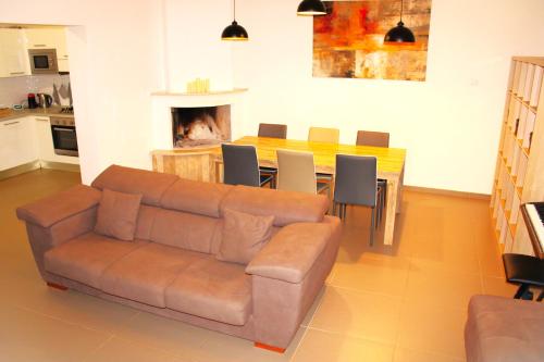 ein Wohnzimmer mit einem Sofa und einem Tisch mit Stühlen in der Unterkunft Villa Costanza in Bari
