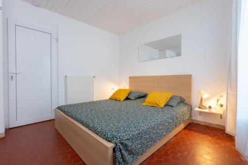 a bedroom with a bed with yellow pillows at Superbe studio cosy et calme in Digne-les-Bains
