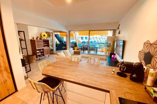 a kitchen and living room with a table and chairs at Le Port Camargue- 2 bedrooms and air-conditioned ! in Le Grau-du-Roi