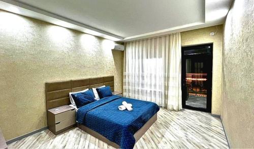 a bedroom with a blue bed with two teddy bears on it at Resort Villa Gabala in Gabala