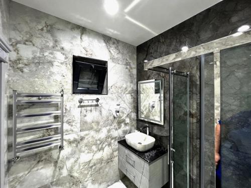 y baño con lavabo y ducha. en Resort Villa Gabala, en Gabala