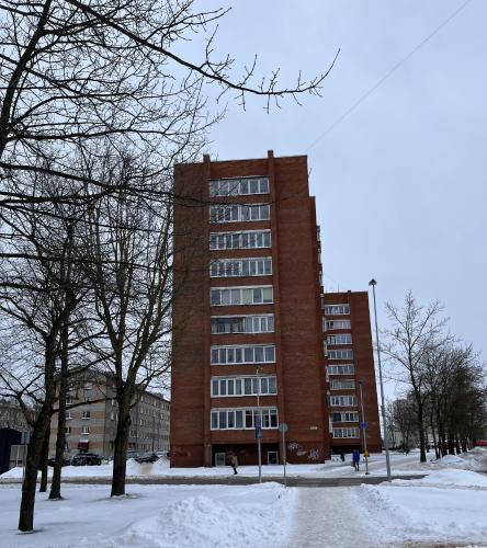 a tall brick building with snow in front of it at Studio with Balcony First floor in the Heart of Narva in Narva