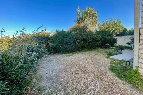 un jardin avec des buissons et un banc à côté d'un bâtiment dans l'établissement Le Maurice - Air conditioning parking and seaside!, à Palavas-les-Flots