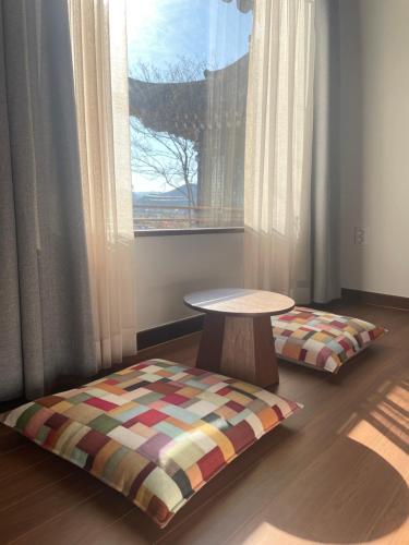 a room with a table and a bench and a window at Hanok Stay SungHyeDang in Gyeongju