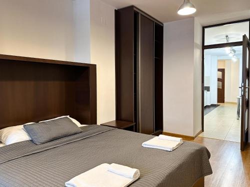 1 dormitorio con 1 cama con 2 toallas en Noclegi Rynek14 Przemyśl Old Town View, en Przemyśl