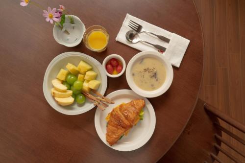 a table with plates of food and fruit on it at Hanok Stay SungHyeDang in Gyeongju