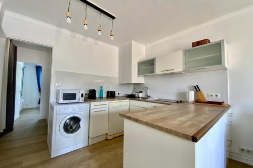 une cuisine avec un lave-linge et un micro-ondes dans l'établissement L’Ensoleïado- Seaside and parking!, à Palavas-les-Flots