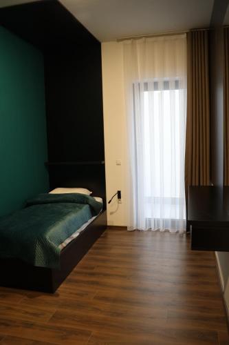 a bedroom with a bed and a large window at Prior Hotel in Prizren