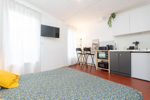 a white room with a bed and a kitchen at Superbe studio cosy et calme in Digne-les-Bains