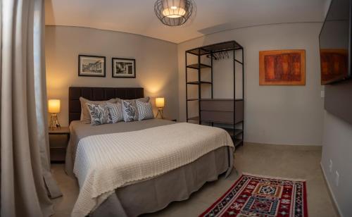 a bedroom with a bed and two lamps and a rug at Casa da Praça 43 in Tiradentes