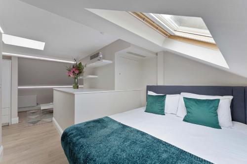 1 dormitorio con 1 cama con almohadas verdes y blancas en Cleveland Residences Russell Square, en Londres