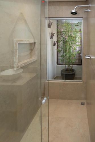 a bathroom with a glass shower with a sink at Casa da Praça 43 in Tiradentes