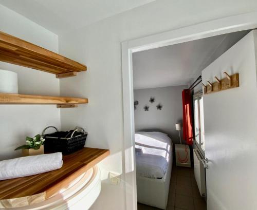 Cette petite chambre comprend un lit et une porte menant à une chambre. dans l'établissement Le fonctionnel - Grande terrasse en plein centre !, à Castelnau-le-Lez