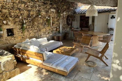 un salon avec un canapé et un mur en pierre dans l'établissement Casa Angel -Bohemian villa with swimming pool and air conditioning!, à Vauvert