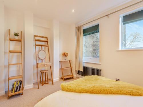 a bedroom with a bed with a yellow blanket at Wye View Cottage in Ross on Wye
