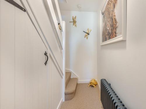 a hallway with a staircase with a door and spiders on the wall at Wye View Cottage in Ross on Wye