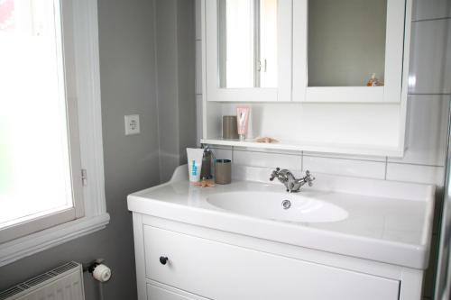 uma casa de banho com um lavatório branco e um espelho. em "Weißes Haus" 9123II - Fehmarn em Fehmarn