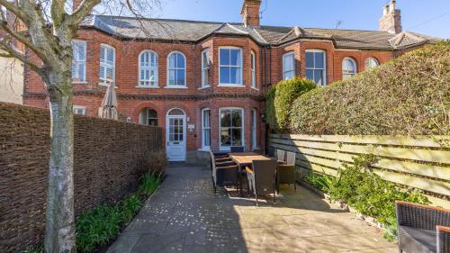 a brick building with a table and chairs in front of it at Vicary's House in Southwold