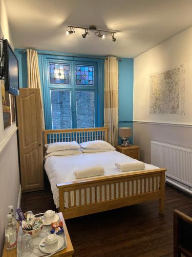 um quarto com uma cama grande e uma mesa em The Old Poets Corner em Chesterfield