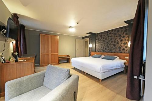 um quarto de hotel com uma cama e um sofá em Hotel Panorama em Bouillon