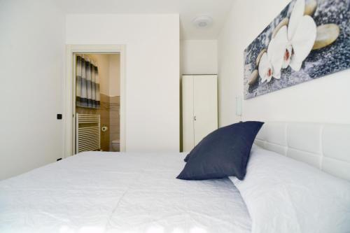 1 dormitorio con cama blanca y almohada azul en B&B La casa di Graz, en Reggio Emilia