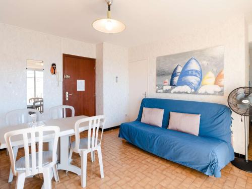 un salon avec un canapé bleu et une table dans l'établissement Studio cabine à 20m de la plage avec balcon et parking à Narbonne-Plage - FR-1-409-140, à Narbonne