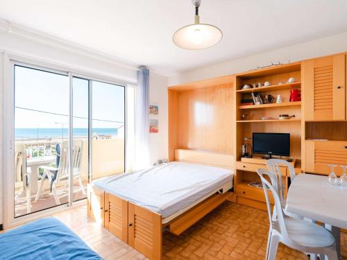 une chambre avec un lit, un bureau et une table dans l'établissement Studio cabine à 20m de la plage avec balcon et parking à Narbonne-Plage - FR-1-409-140, à Narbonne