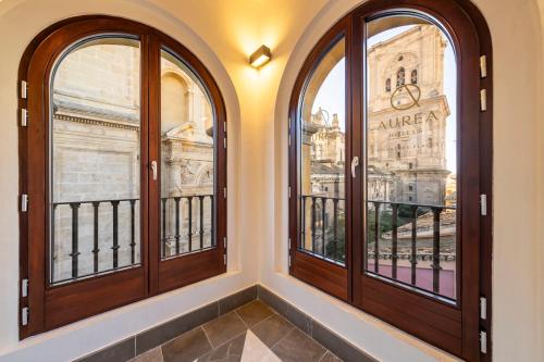 a room with three windows with a view of the city at Áurea Catedral by Eurostars Hotel Company in Granada