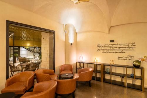 a waiting room with orange chairs and a table at Áurea Catedral by Eurostars Hotel Company in Granada