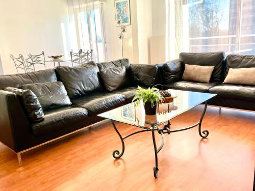 - un canapé en cuir noir dans le salon avec une table basse dans l'établissement City Break Picquecailloux, à Bordeaux