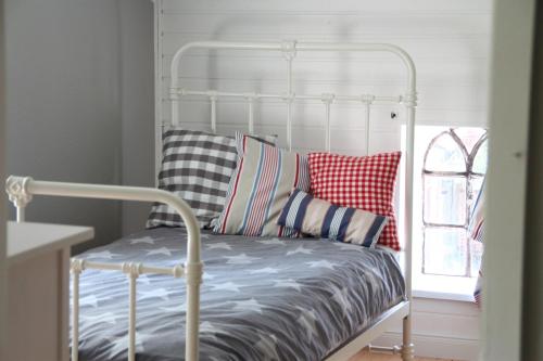 uma cama com almofadas coloridas num quarto em "Weißes Haus" 9123II - Fehmarn em Fehmarn