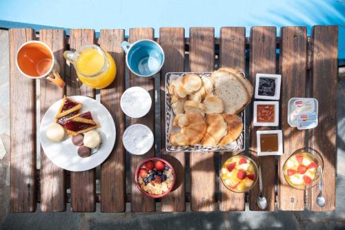 a wooden table topped with breakfast foods and drinks at Posada del Viento in Tandil