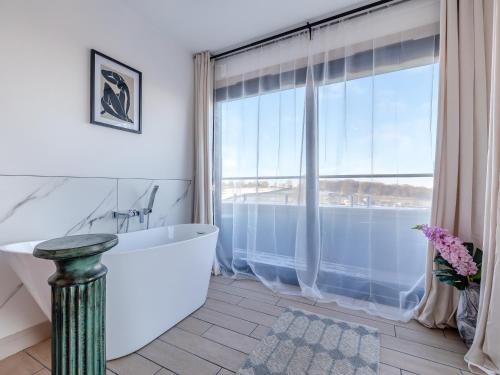 a bathroom with a tub and a large window at The Bungalow in Rushton Spencer