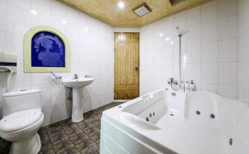 a bathroom with a toilet and a tub and a sink at Cheongju Ochang memory stay in Cheongju