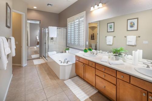 uma casa de banho com 2 lavatórios, uma banheira e um WC. em Phoenix Vacation Rentals em Phoenix