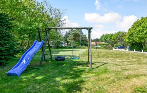 a playground with a blue slide in a field at Amazing Home In Oksbøl With Wifi in Oksbøl