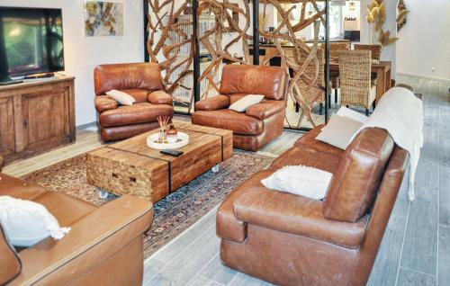 Il comprend un salon doté d'un mobilier en cuir et d'une télévision. dans l'établissement 2 Bedroom Cozy Home In Aramon, à Aramon