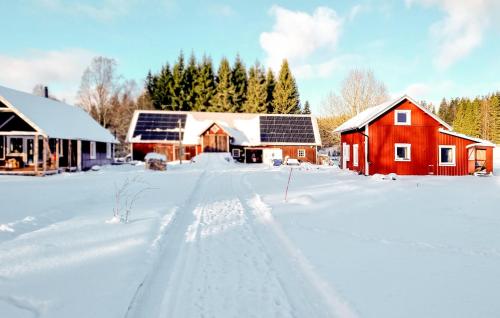 a snow covered yard with a red barn and buildings at Amazing Home In Bottnaryd With Wifi in Bottnaryd