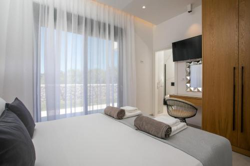 a bedroom with a large white bed with a window at Ocean Pearl Sea View in Faliraki