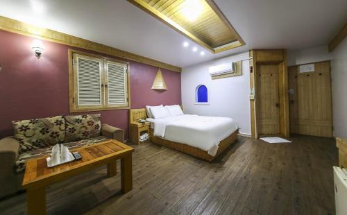 a hotel room with a bed and a couch at Cheongju Ochang memory stay in Cheongju