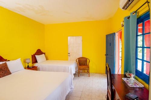 ein Schlafzimmer mit 2 Betten und einer gelben Wand in der Unterkunft Waterloo Guest House in Black River