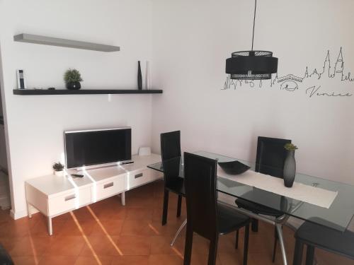 a dining room with a table with chairs and a television at Rox Apartment - 027023-LOC-00174 in Mira