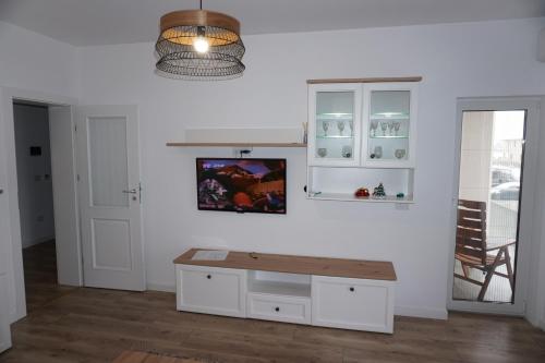 uma cozinha com armários brancos e uma mesa de madeira em Rosi Residence em Chişoda