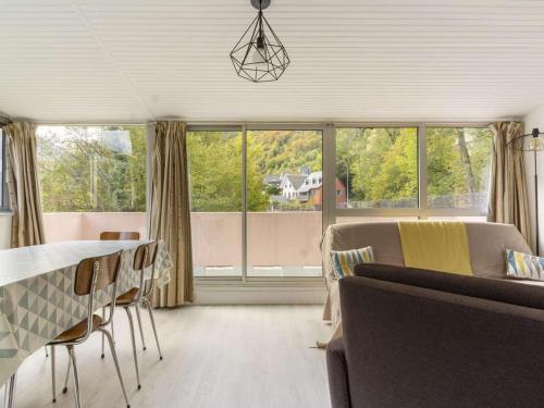 - un salon avec une table, des chaises et une grande fenêtre dans l'établissement Appartement 4-6 Pers, Exposé Sud, Parking, Balcon, Proche Navette Gratuites, Râtelier à Ski - FR-1-401-152, à Cauterets