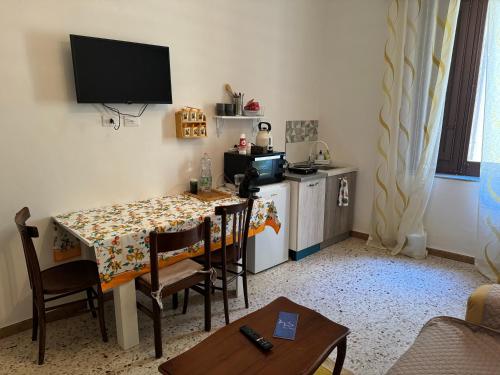 ein Wohnzimmer mit einem Tisch und einer Küche in der Unterkunft Elico Di Sicily B@B in Sambuca di Sicilia