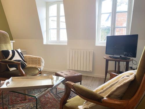 un soggiorno con due sedie e una TV a schermo piatto di Klimt - Parking - Independent Entrance a Chartres