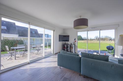 un salon avec un canapé et une porte coulissante en verre dans l'établissement Les Vignets comfortable holiday home, à Sainte-Honorine-des-Pertes