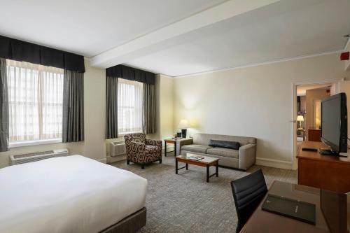 a hotel room with a bed and a living room at Hilton Cincinnati Netherland Plaza in Cincinnati
