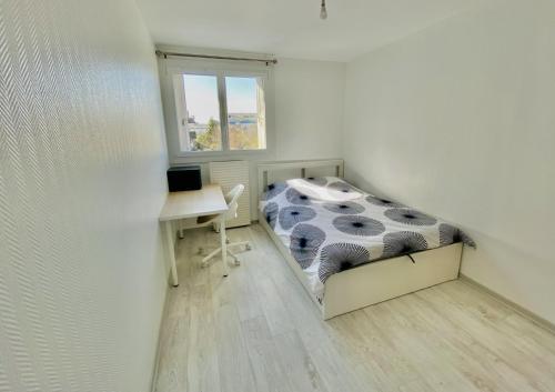 Habitación pequeña con cama y escritorio. en Appartement T3 de Standing en Centre-Ville, en Joué-lès-Tours